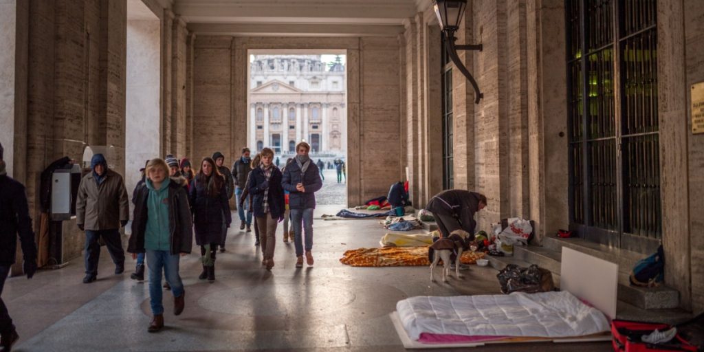 A group of homeless people begs for pennies in front of St. Peter's Basilica in the Vatican City
