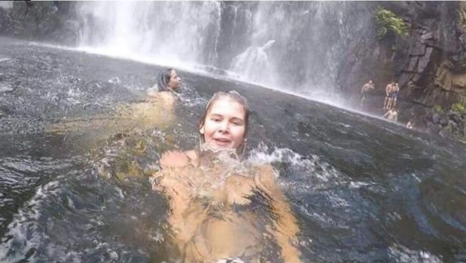 Young woman takes selfie in front of waterfall, later discovers shocking moment captured in the background
