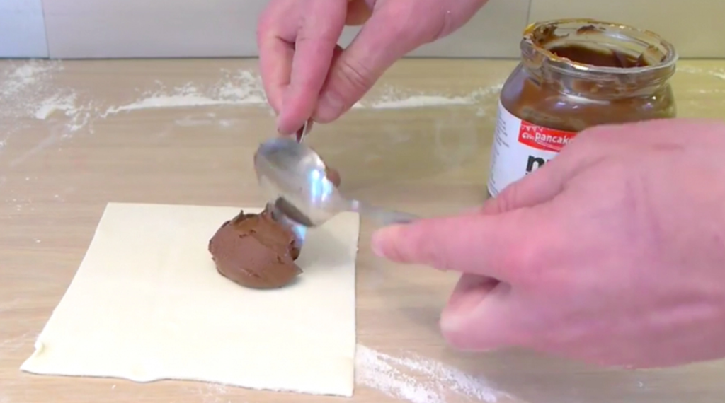 He places a dollop of nutella on puff pastry: The result is heavenly